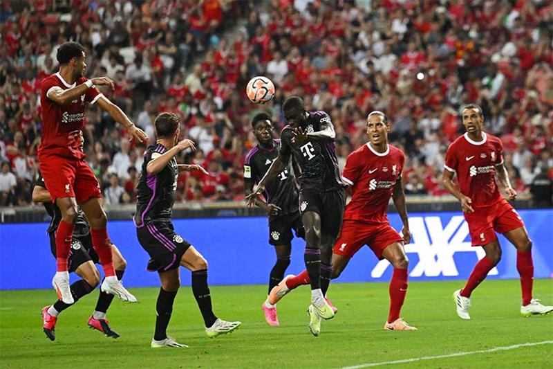 Le défenseur français du Bayern Munich, Dayot Upamecano (C), joue de la tête contre les joueurs de Liverpool. 